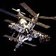 Une image de la station Mir composé de quatre modules (le plus à droite une plus petite avec un module d'orange fixée à son extrémité distale) disposé en forme de croix autour d'un noeud central d'amarrage. Un sixième les projets de module vers l'arrière depuis ce noeud, et a un septième, plus petit module soit fixé à l'extrémité distante. Un vaisseau Soyouz est amarré à la fin de cette pile. Chacun des modules projette divers plumeuses solaires tableaux, les antennes et les fermes, et la noirceur de l'espace forme la toile de fond de l'image.