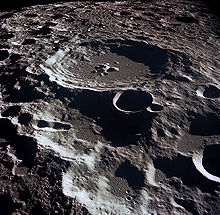 Une surface grise, beaucoup-striée d'en haut. La fonctionnalité la plus grande est une structure circulaire avec annelé côtés haute paroi et un pic central inférieur: toute la surface à l'horizon est rempli avec des structures similaires qui sont plus petits et se chevauchent.