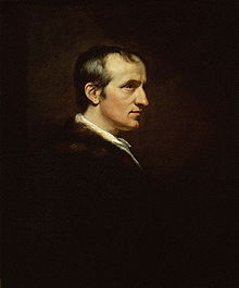 Demi-longueur profil portrait d'un homme. Son vêtements sombres fond dans le paysage et son visage blanc est à l'opposé.