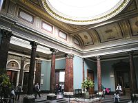 Oblong, salle en forme de dôme, le plafond soutenu par des colonnes en marbre brun