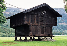 Une petite cabane entièrement composé de bûches fendues, et élevé au-dessus du sol sur des souches verticaux robustes.