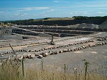 Grande étendue de roche grise exposée. Clôture au premier plan.