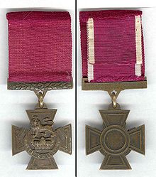 L'avers et le revers de la médaille de bronze croix pattée; avers montrant la couronne de Saint-Édouard surmontée d'un lion avec l'inscription FOR VALOUR avec un ruban pourpre; l'inverse montre l'inscription du destinataire sur la barre de liaison le ruban avec le régiment dans le centre de la médaille.