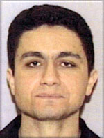 A head shot of a man in his thirties looking expressionless toward the camera