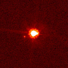Eris (centre) et Dysnomie (gauche du centre), prise par le télescope spatial Hubble