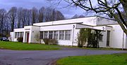 Blanc bâtiment de plain-pied en béton, avec une végétation autour