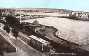 Une vieille photographie d'un tramway longeant une route de bord de mer.