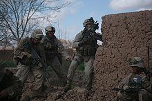 Soldats à côté d'un mur de boue