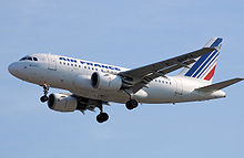 Blanc avions à réaction entrée en terres, train d'atterrissage entièrement déployée. Sous chaque aile est un turboréacteur à double flux