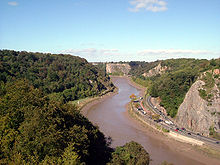 Rivière qui coule à travers les gorges boisées avec des côtés. Sur la rive droite est une route.