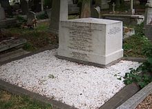 Un travail en marbre blanc cubique de la maçonnerie, environ trois pieds de large, 18 cm de profondeur et de deux mètres de haut, inscrit avec les noms des membres de la famille Brunel, entouré de gravillons de marbre