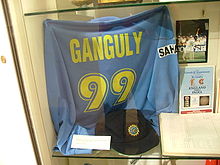 Un T-shirt de couleur bleue affichée à une vitrine de magasin. Le t-shirt a les mots