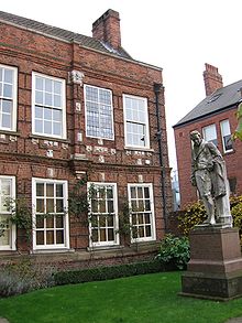 statue sur une pelouse d'une maison géorgienne de deux étages