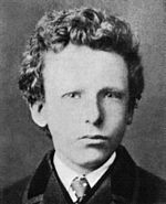 noir et blanc headshot formelle photo de l'artiste comme un garçon en veste et cravate. Il a les cheveux bouclés et les yeux très épaisse de couleur pâle avec une expression inquiète méfier.