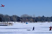 La gente volando cometas en el Lago Harriet congeladas y cubiertas de nieve