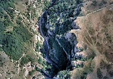 Jagged área azul oscuro de la garganta correr formar la parte inferior izquierda a la superior derecha, rodeado de zonas más altas marrones y verdes de la tierra