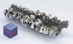 Una masa de cristales brillantes de color gris con facetado hexagonal