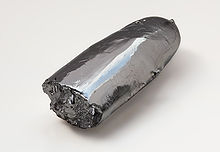 Un bar irregular de metal plateado brillante. Un extremo es áspera, como si roto, mientras que el otro extremo, en forma de cigarro es relativamente suave.
