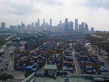 El puerto de Singapur con un gran número de contenedores de transporte con el horizonte de la ciudad visible en el fondo
