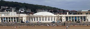 Edificio blanco detrás de la playa. Cuenta con una cúpula y columnas a izquierda y derecha.